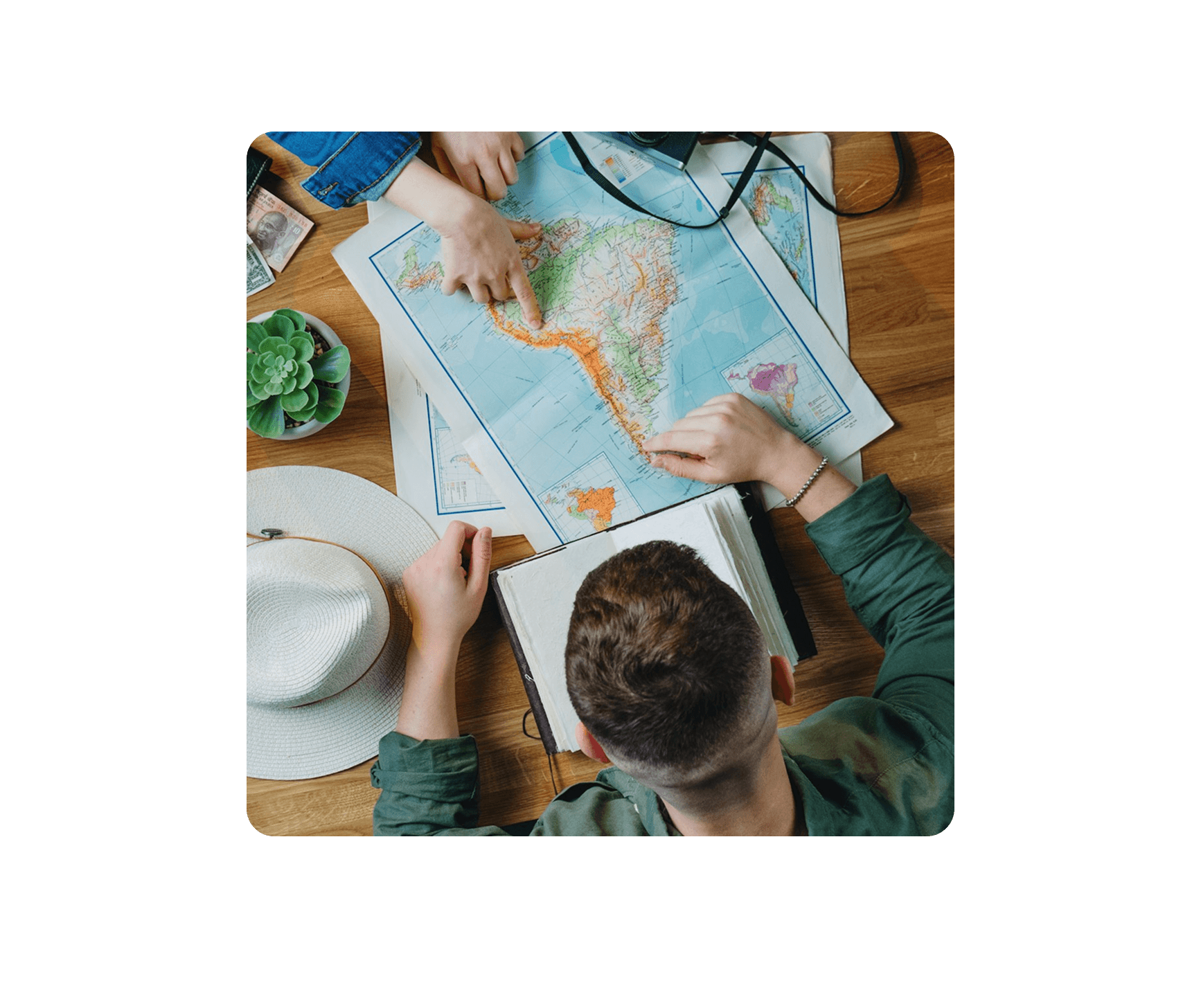 2 people is planning their trip on a map and a note book that they can later explore it on Travous where they can explore more places, activities much easier.